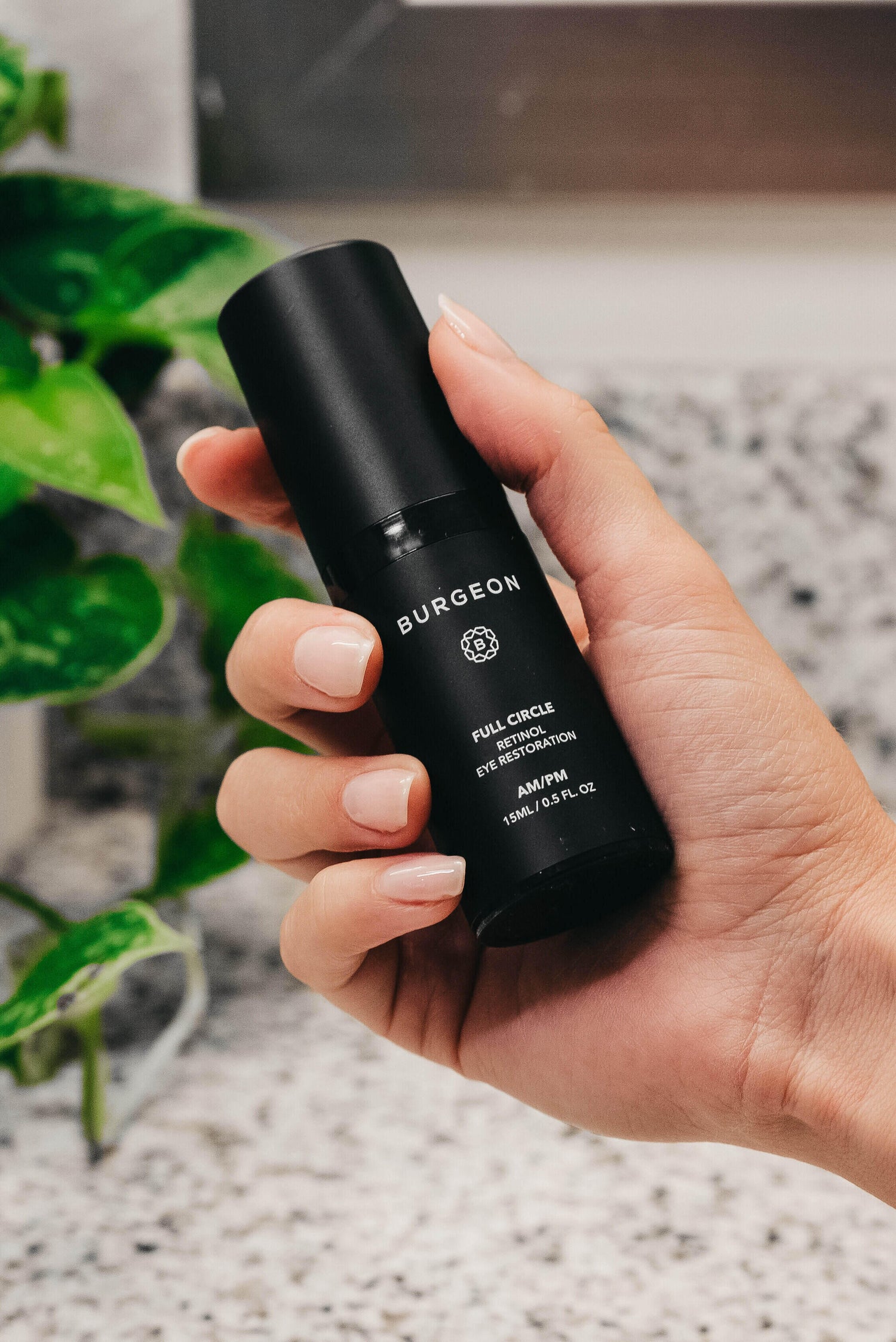 woman holding bottle of full circle retinol serum in hand
